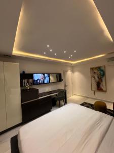阿布贾Austra Villa Maitama Abuja的一间卧室配有一张床、一张书桌和一台电视。
