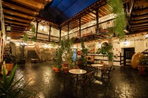 库斯科Hotel Hacienda Cusco Plaza的配有桌椅和盆栽的植物的房间