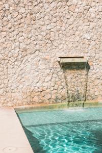 梅里达外交官精品酒店的石墙旁边的游泳池