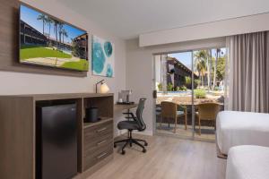 圣巴巴拉贝斯特韦斯特胡椒树酒店的酒店客房设有一张床、一张书桌和一台电视机。