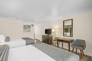 蒙特雷蒙特雷贝斯特韦斯特科瑞斯特公园酒店的酒店客房设有两张床、一张桌子和一台电视。
