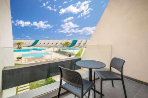卡塔赫纳Occidental Mar Menor的一个带桌椅的阳台和一个游泳池