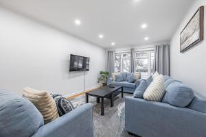 多伦多Littlewood Properties的客厅配有2张蓝色的沙发和1张桌子
