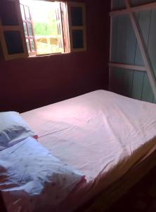 Santo AntónioCasas Salomão的窗户客房内的一张带白色床单的床
