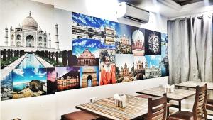 新德里Airport Hotel Delhi Aerocity的餐厅设有两张桌子和一幅壁画,