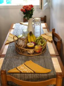 圣但尼Primerose villa的一张桌子,上面放着一篮水果和一瓶花