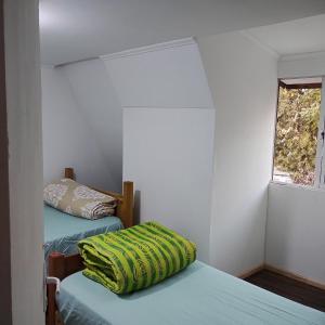 圣地亚哥Backpackers House - Near The Airport的小房间设有两张床和窗户
