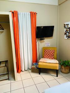 伯利兹城City Garden Apartment的客厅配有橙色窗帘和椅子