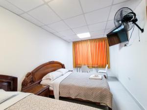 齐克拉约SANTA VICTORIA HOUSE的酒店客房配有两张床和风扇