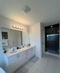 卡沃萨湖Brand new luxurious home, located in Lindsay.的一间带两个盥洗盆和大镜子的浴室