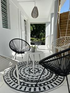 圣克洛德Maison La Caféière的地毯上设有带两把椅子和一张桌子的庭院