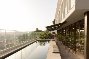 里斯本王储花园梅莫设计酒店的一座带游泳池和桌椅的建筑