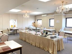 北见Hotel Royal Kitami - Vacation STAY 04905v的大房间设有桌椅和吊灯
