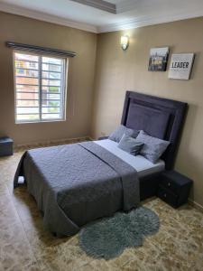 伊凯贾Dvyne Luxury Home的一间卧室设有一张大床和窗户