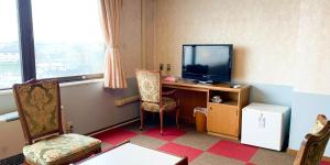 北见Hotel Royal Kitami - Vacation STAY 06513v的客房设有一张桌子、一台电视和一把椅子