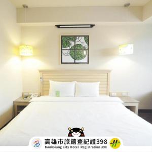 高雄康桥商旅-七贤馆的卧室配有一张白色床,墙上挂着一幅画