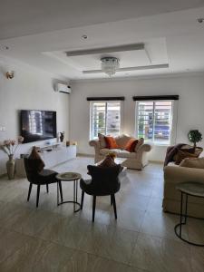 伊凯贾Dvyne Luxury Home的带沙发和椅子的客厅以及电视