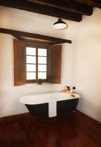 雷亚尔卡托尔塞Casa Grande - Adults Only的窗户客房内的浴缸