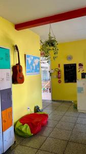 弗洛里亚诺波利斯Pequi hostel的墙上有一个黄色的房间,墙上有吉他