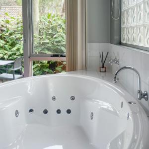坎贝尔港波浪豪华套房酒店的带窗户的浴室内的白色浴缸
