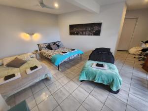 黄金海岸Self Contained Guesthouse for 7ppl, w Pool的一间带两张床和一张沙发的客厅