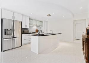 塔南达Premium Barossa Getaway的厨房配有白色橱柜和不锈钢用具