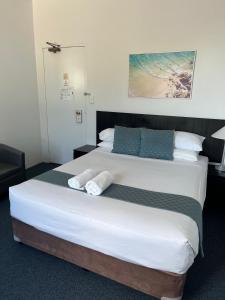 悉尼圣伦纳兹酒店的一间卧室配有一张大床和毛巾