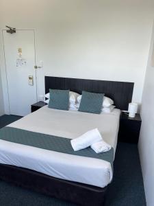 悉尼圣伦纳兹酒店的卧室配有带蓝色枕头的大型白色床