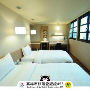 高雄康桥商旅-高雄站前馆的酒店客房配有两张床和一张书桌