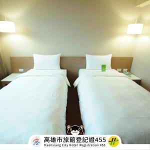 高雄康桥商旅-高雄站前馆的配有白色床单的酒店客房内的两张床