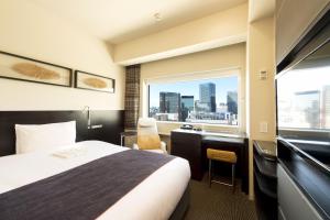 东京remm Akihabara的配有一张床、一张书桌和一扇窗户的酒店客房