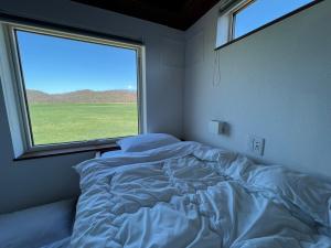 标茶町FLEXWORK tawa的卧室内的一张床铺,设有大窗户