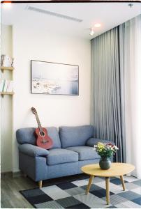 兴安Tofu's House - 2 BR APT in Sol Forest - Ecopark的客厅配有蓝色沙发和吉他