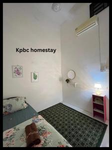 日得拉Kpbc Homestay 3bilik的一间卧室,配有一张床和一个读取kpie同质的标志