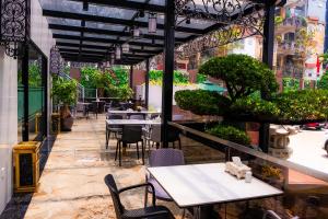 河内首都花园酒店的庭院内的餐厅,配有桌椅