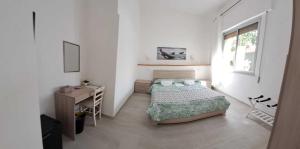 维拉西米乌斯Pratza Froria的一间卧室配有一张床、一张书桌和一个窗户。