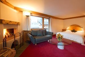 席尔瓦普拉纳阿尔巴纳斯尔瓦普拉那酒店的一间卧室配有一张床、一把椅子和一个壁炉