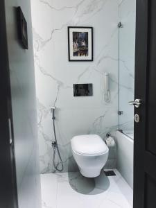 加尔各答Peerless Hotel Kolkata的白色的浴室设有卫生间和浴缸。