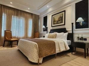加尔各答Peerless Hotel Kolkata的一间卧室配有一张床、一张桌子和一把椅子