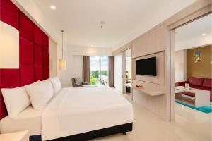 班贾尔马辛ASTON Banua Banjarmasin Hotel & Convention Center的卧室配有一张白色大床和电视。