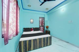 BihtaOYO Flagship R K Marriage Hall and Guest House的一间设有床铺的卧室,位于一间拥有蓝色墙壁的房间
