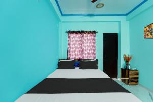 BihtaOYO Flagship R K Marriage Hall and Guest House的一间卧室配有一张蓝色墙壁的床和一扇窗户