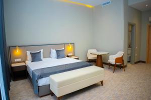 巴库Port Marine Hotel的酒店客房带一张床、一张桌子和椅子