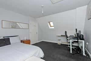Kent5 Bedroom House Great For Contractors Leisure Stays & Relocation By AV Stays Kent的一间卧室配有一张床和一张带电脑的书桌