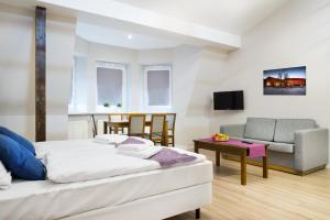 克拉科夫埃茂斯公寓式酒店的一间卧室配有一张床、一张沙发和一把椅子