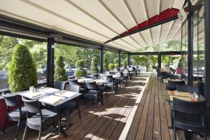 马恩河畔尚宜必思马恩河谷香格里拉香榭马恩河畔酒店的一间在甲板上配有桌椅的餐厅
