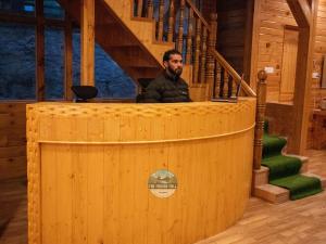 古尔马尔格The Frozenfall Resort的坐在木舱讲台上的人