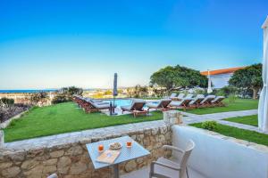 科林瓦里奥Panthea Luxury Living的一个带桌椅的庭院和一个游泳池