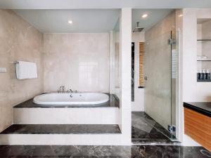 曼谷优本纳朗双 七隆的一间带浴缸和淋浴的浴室
