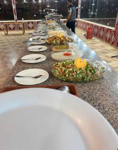 瓦迪拉姆Siwar Luxury Camp的餐桌上盘子的长自助盘
